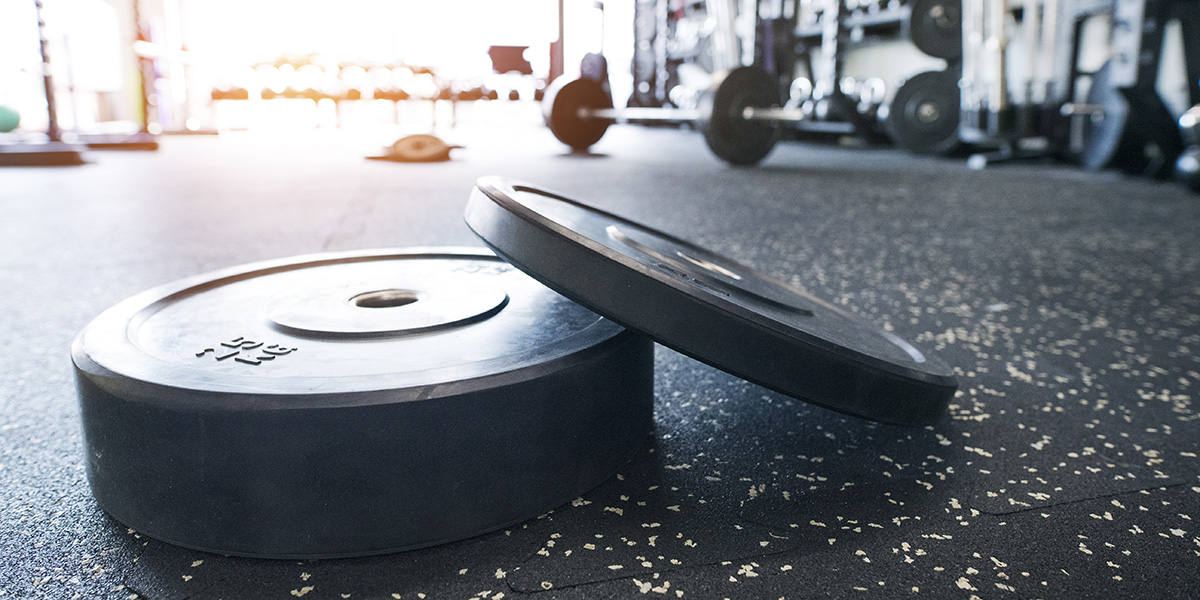 heavy weights on the interlocking rubber floor in modern gym.